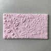 Rectangular fondant cookie with detailed floral embossing using a Christmas cookie stamp