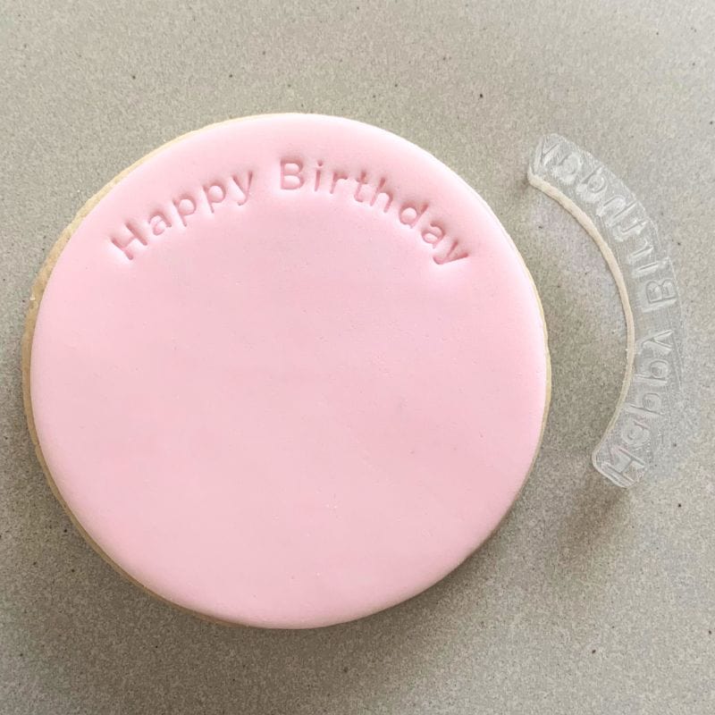 Curved 'Happy Birthday' stamp design on celebratory fondant cookie