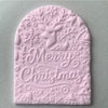 Arched fondant cookie embossed with Merry Christmas and reindeer design using a magical embosser stamp