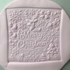 Square fondant cookie embossed with a reindeer and holiday patterns using a Christmas-themed embosser stamp