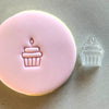 Cupcake-shaped stamp imprint on birthday-themed fondant cookie