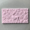 Rectangular fondant cookie with reindeer and snowflake details from a holiday-themed embosser stamp
