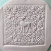 Square fondant cookie featuring a reindeer and holiday patterns using a Christmas embosser stamp