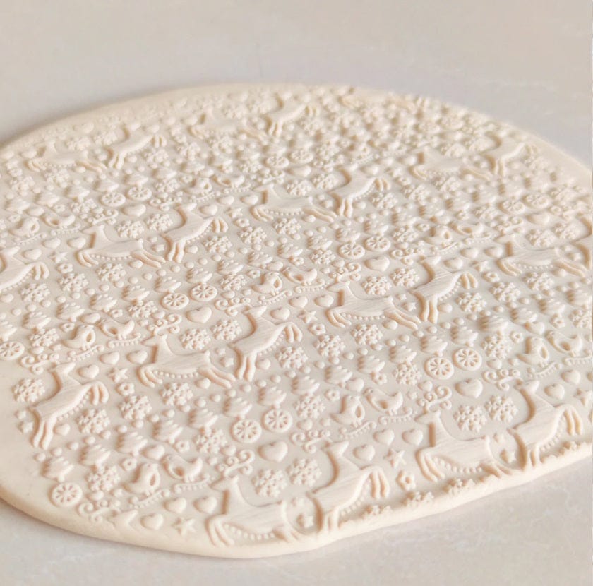 christmas fondant cookie decorated with reindeer designs from an acrylic rolling pin