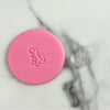 mini dinosaur fondant embosser stamp on pink fondant