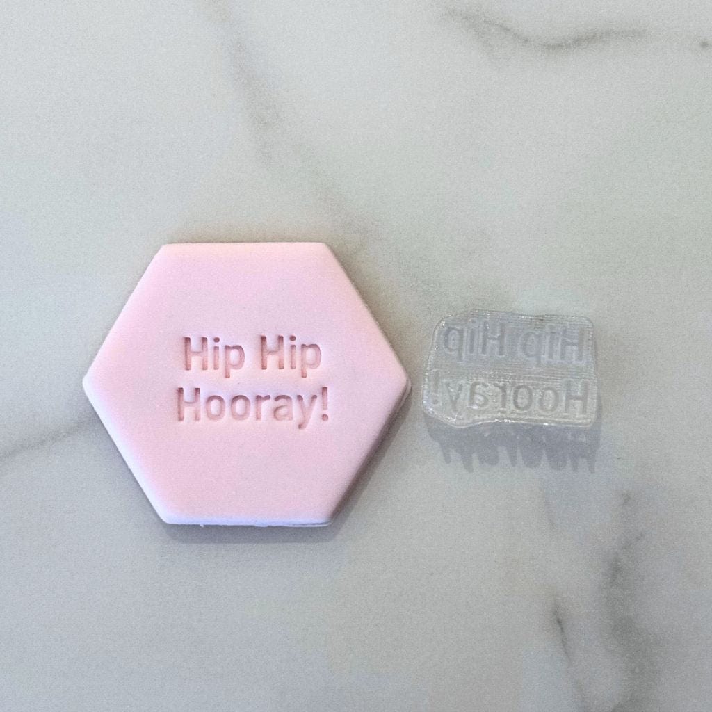 Hip Hip Hooray fondant cookie with matching cookie stamp on marble background