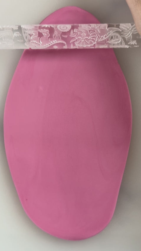 rolling the dinosaur embossed rolling pin texture on fondant